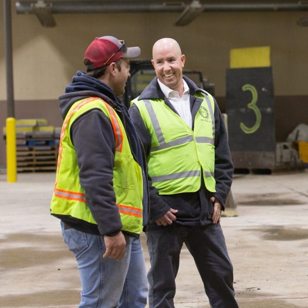 two men wearing safety vests